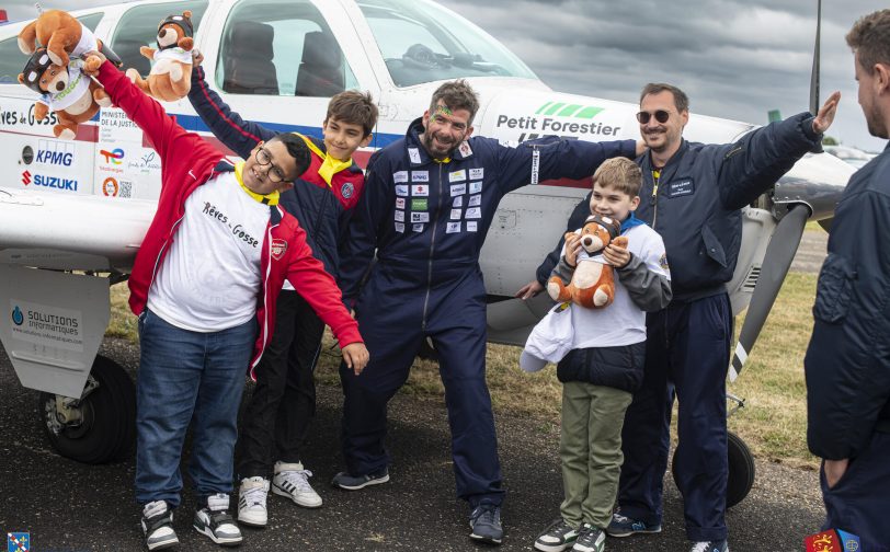Pilotes et enfants prenant la pose pour l'opération rêves de gosses devant un avion - Agrandir l'image, fenêtre modale